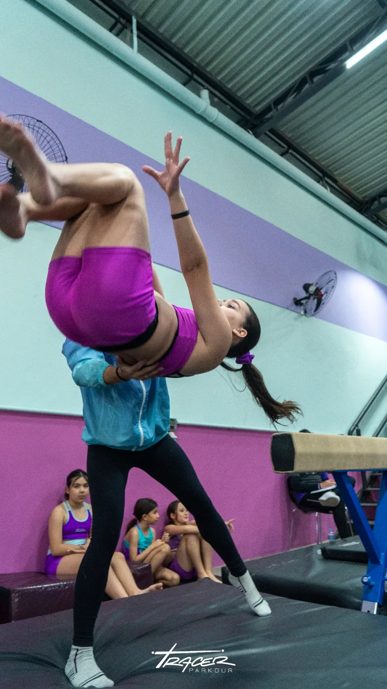 Professora auxiliando aluna em movimento invertido