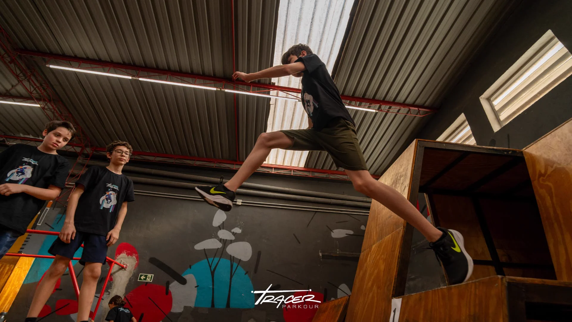 Aluno executando salto entre obstáculos durante aula