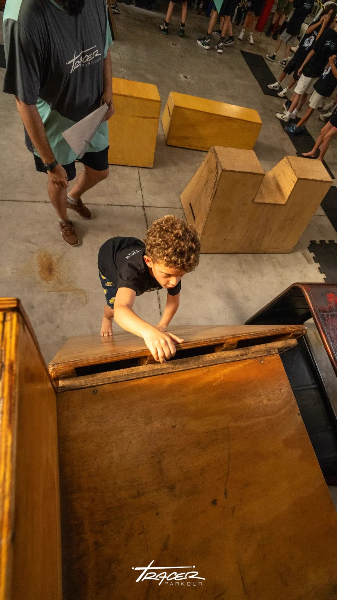 Aluno subindo em plataforma de madeira durante aula